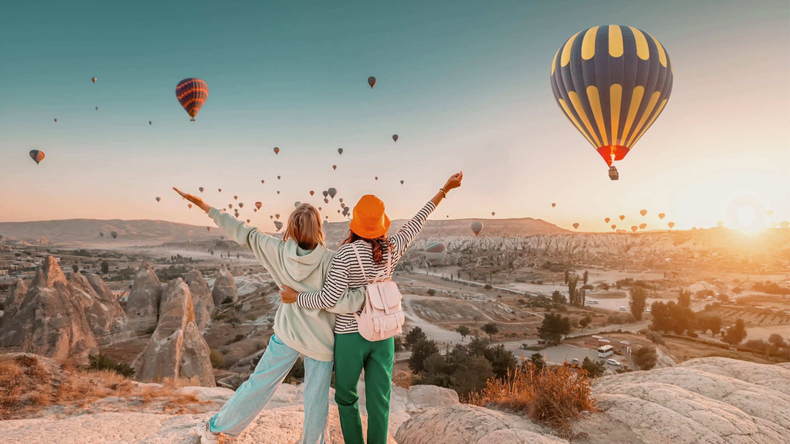 Travellers watch hot air balloons rise over Cappadocia at sunrise on the Contiki Best of Turkey Tour