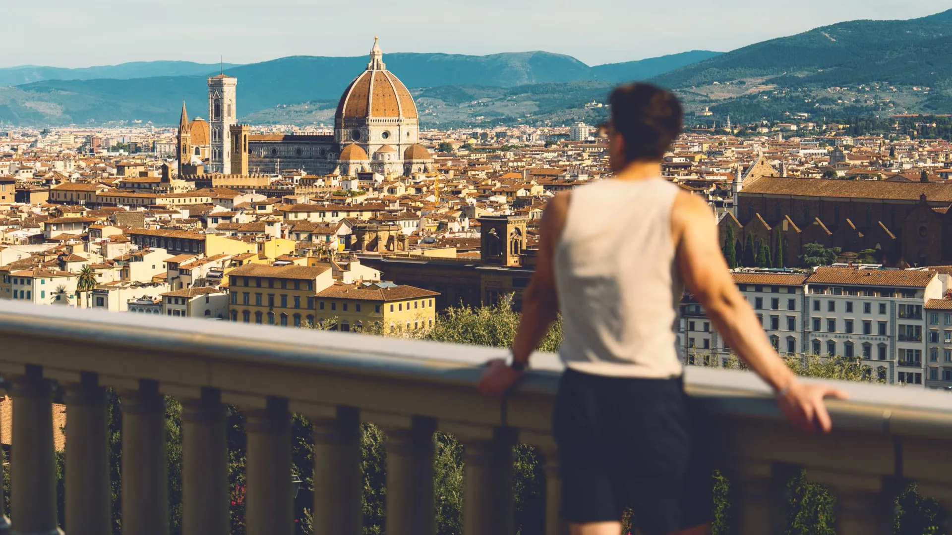 Traveller at Piazzale Michelangelo overlooking the Florence skyline with Brunelleschi's Duomo and Campanile in Tuscany Italy - Contiki European Discovery Tour
