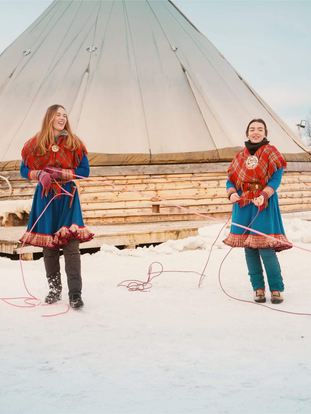 Travellers experience Sámi culture outside a traditional lavvu tent in Norway