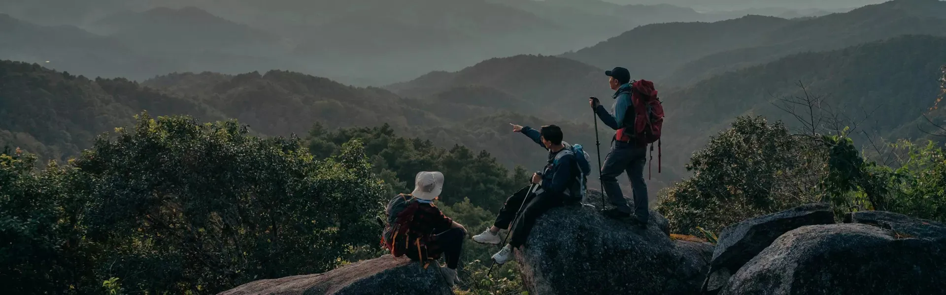 Three people hiking and observing the sunset in a clear sky in Costa Rica.