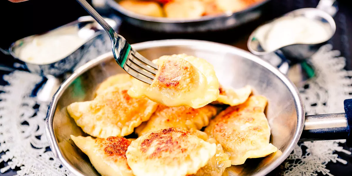 Eating Traditional Polish Dumplings Pierogi With Fork