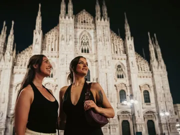 Two girls admiring Milan Cathedral (Duomo di Milano) at night - Contiki Paris to Rome by Train Tour