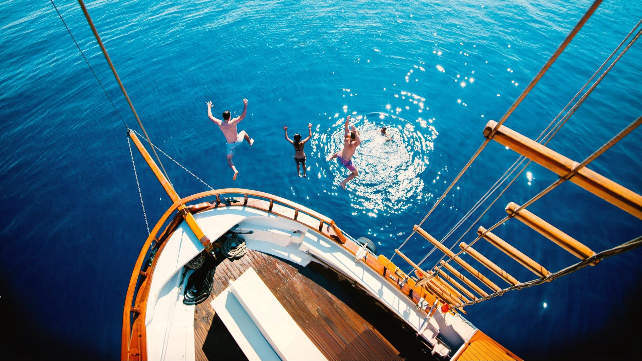 Travellers jump from a sailing boat into the crystal-clear Aegean Sea on Contiki's Greek Island Hopping 35 to 45 Tour