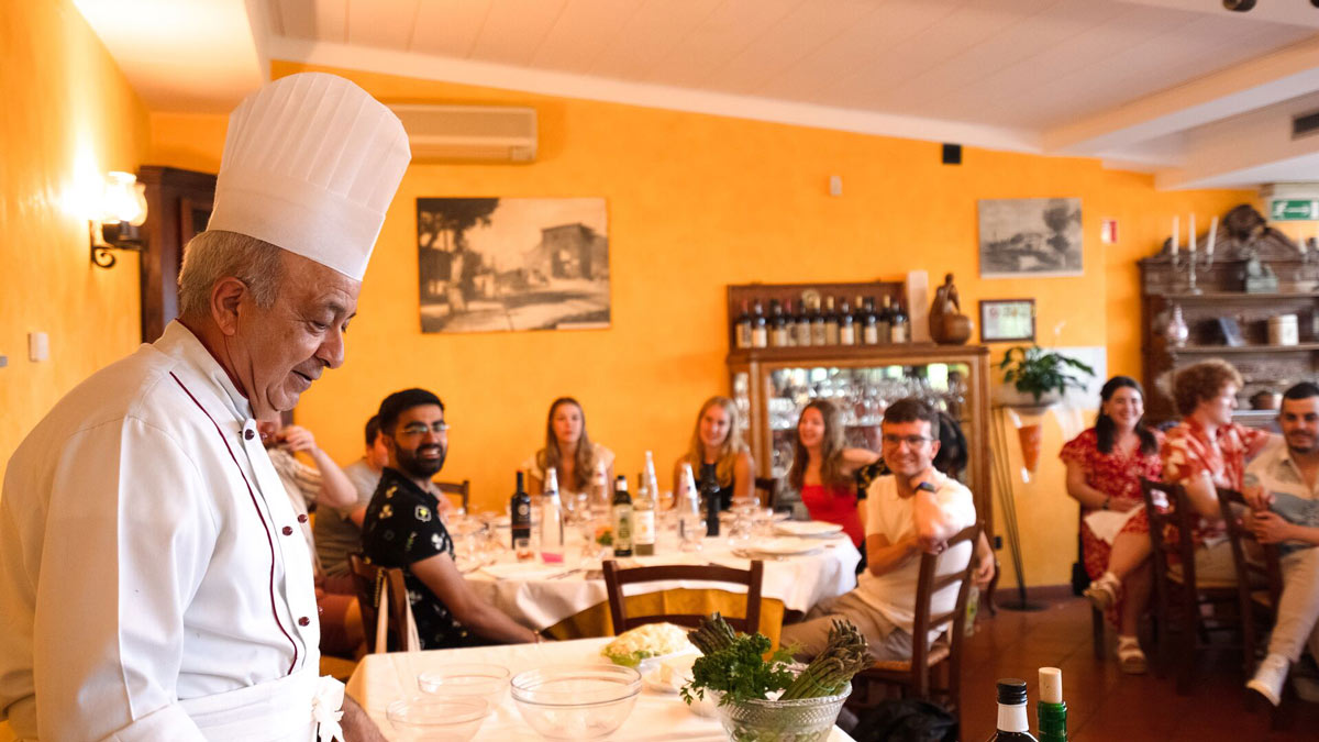 Chef Talking To A Young Group Of People In His Restaurant