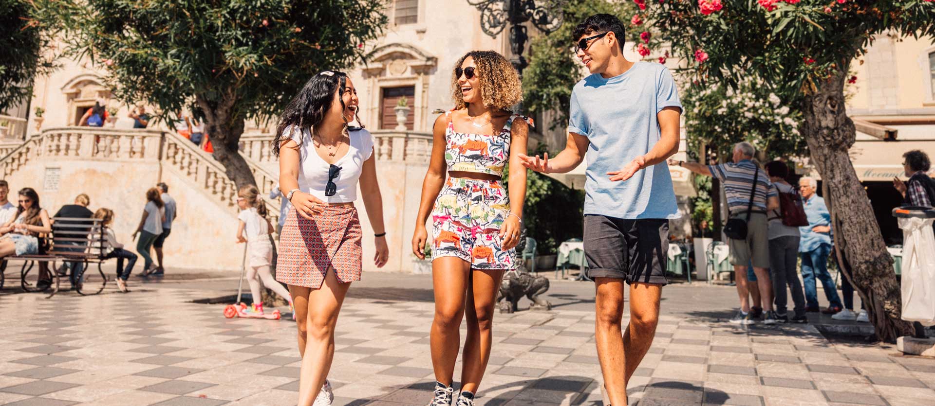 Group of travelers talking and laughing in the sun, Sicily