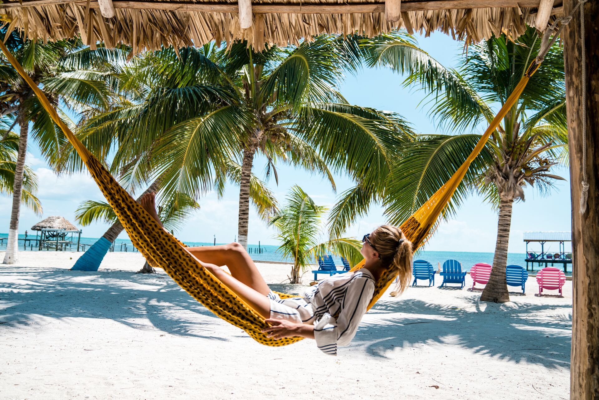 A woman laying in a hammock on the beach, Caribbean