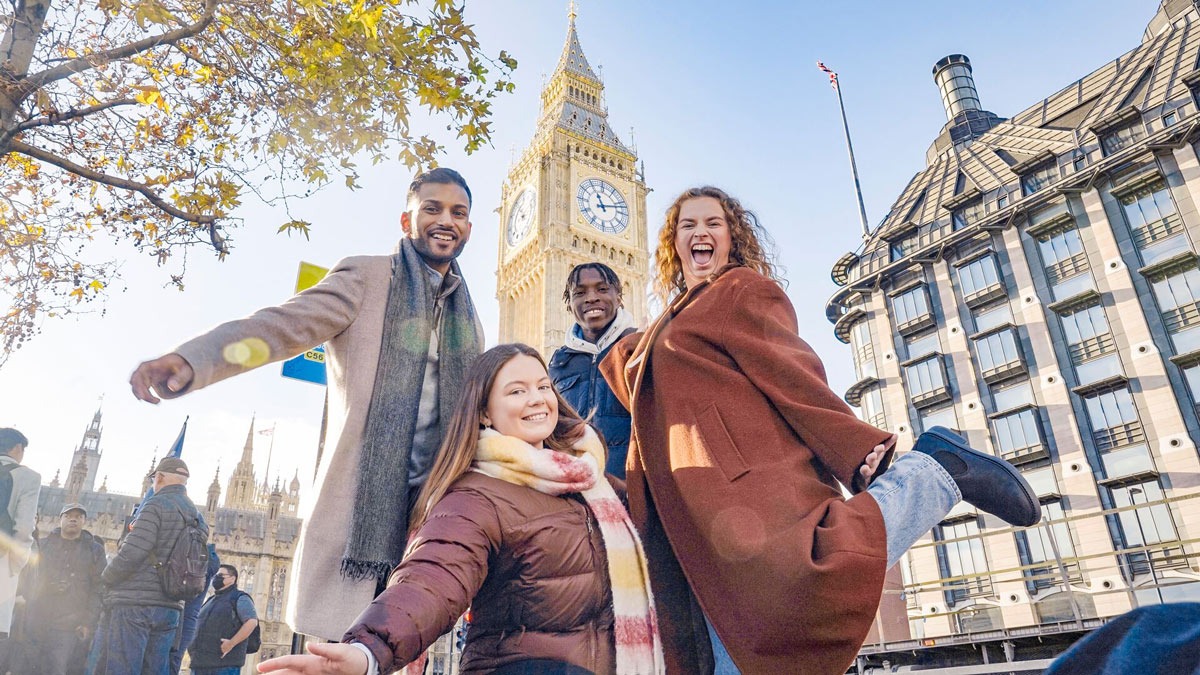 A group of friends smiling with Big Ben at the back in England.