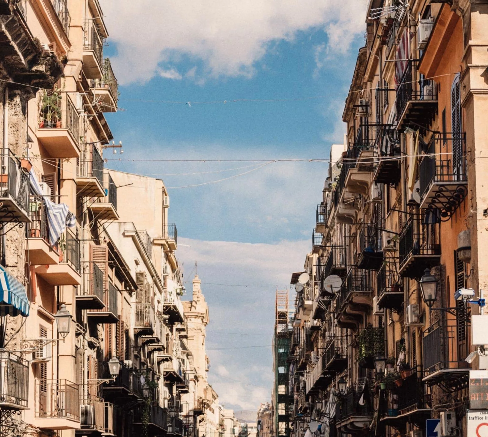 Historic street in Sicily, Italy, lined with colourful buildings and balconies on the Contiki Sicily Escape Tour