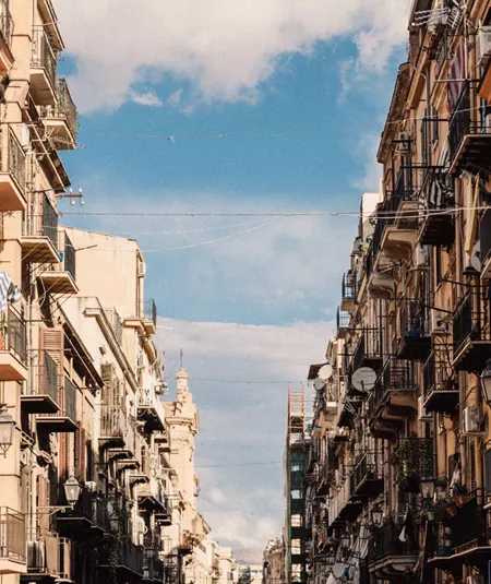 Historic street in Sicily, Italy, lined with colourful buildings and balconies on the Contiki Sicily Escape Tour