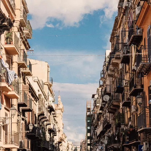 Historic street in Sicily, Italy, lined with colourful buildings and balconies on the Contiki Sicily Escape Tour