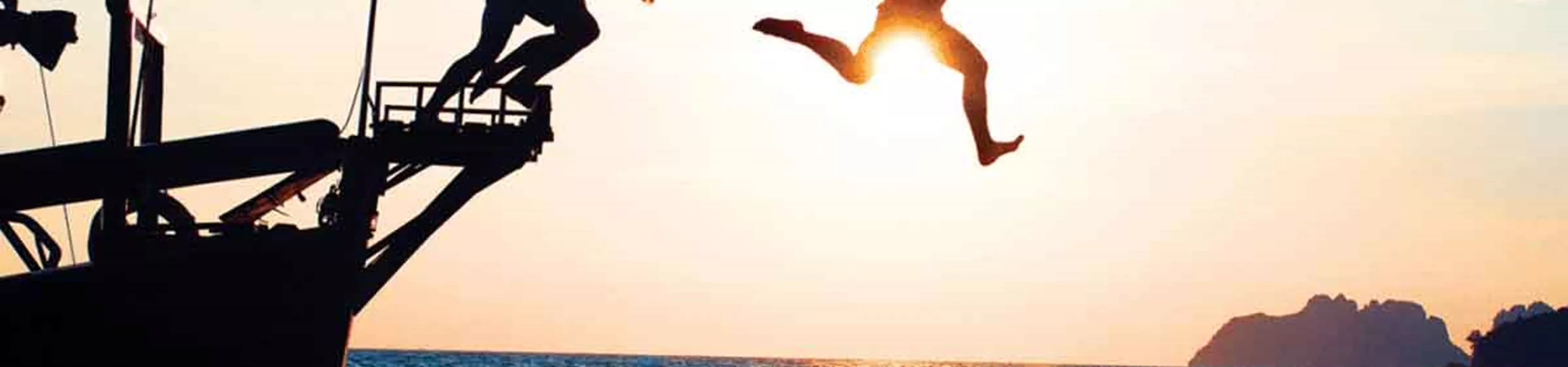 Sunset and people jumping from boat to sea