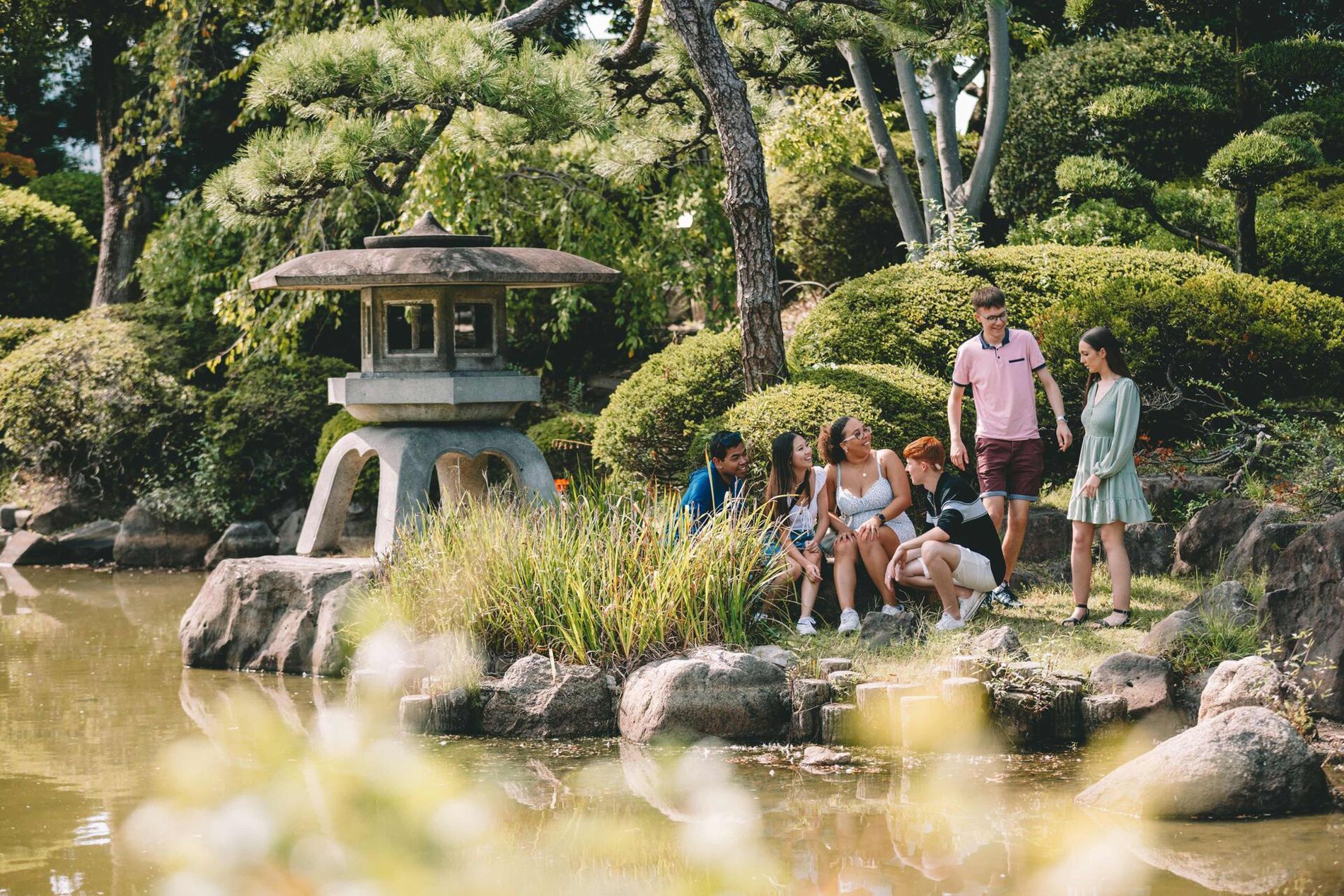 Japan Osaka Group Of Young People Enjoying A Moment In A Beautiful Garden