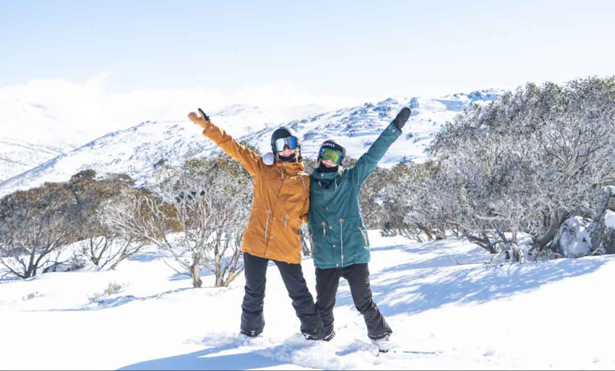 Two Snowboarders In Snow Posinging For Shot