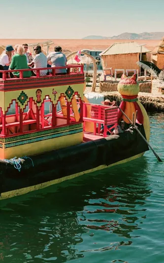 Contiki travellers cruising on a traditional reed boat at the Uros Floating Islands on Lake Titicaca, experiencing local culture on the Peru Uncovered Tour