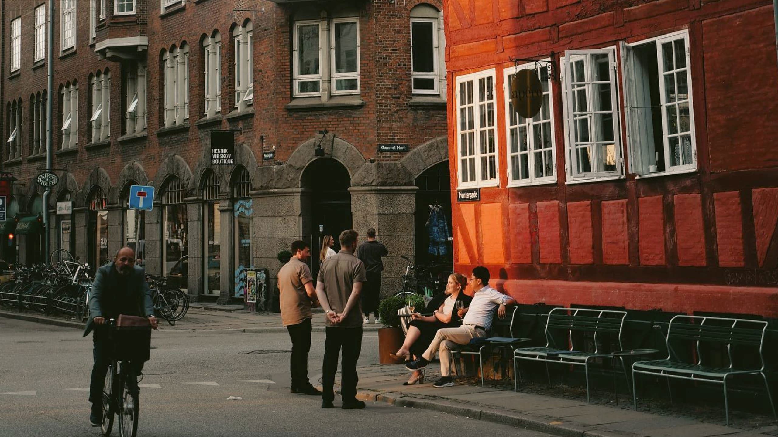 People enjoying a café on a historic street in Copenhagen, Denmark - Contiki Best of Scandinavia & The Baltics Tour