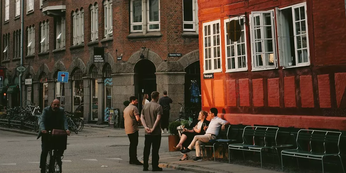 People enjoying a café on a historic street in Copenhagen, Denmark - Contiki Best of Scandinavia & The Baltics Tour
