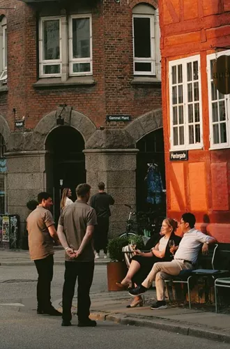 People enjoying a café on a historic street in Copenhagen, Denmark - Contiki Best of Scandinavia & The Baltics Tour