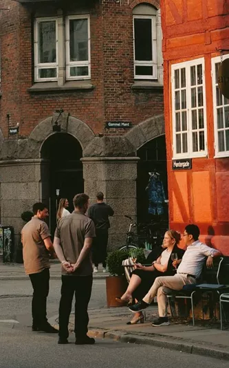 People enjoying a café on a historic street in Copenhagen, Denmark - Contiki Best of Scandinavia & The Baltics Tour