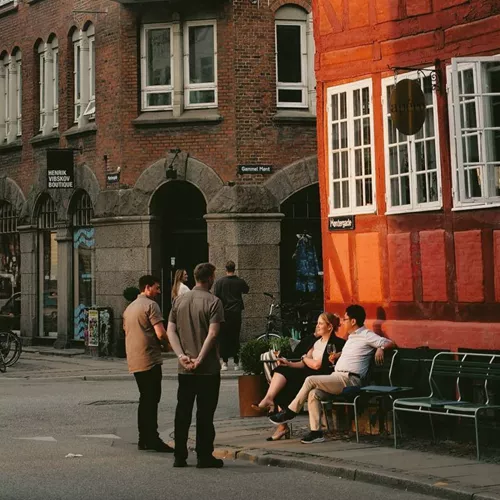 People enjoying a café on a historic street in Copenhagen, Denmark - Contiki Best of Scandinavia & The Baltics Tour