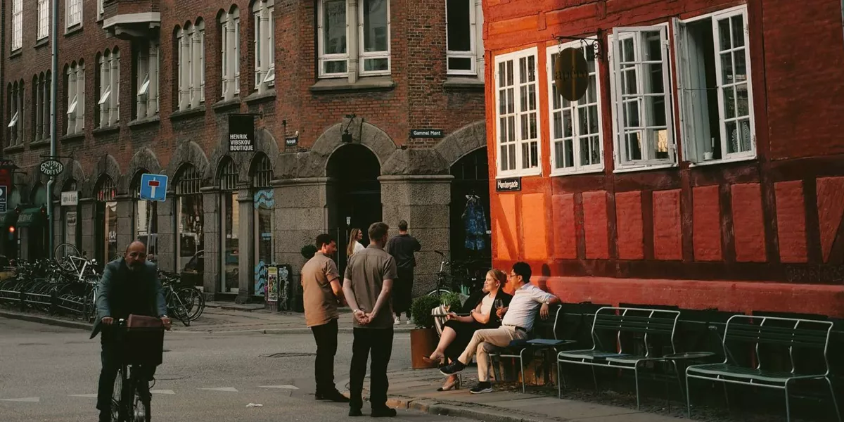 People enjoying a café on a historic street in Copenhagen, Denmark - Contiki Best of Scandinavia & The Baltics Tour