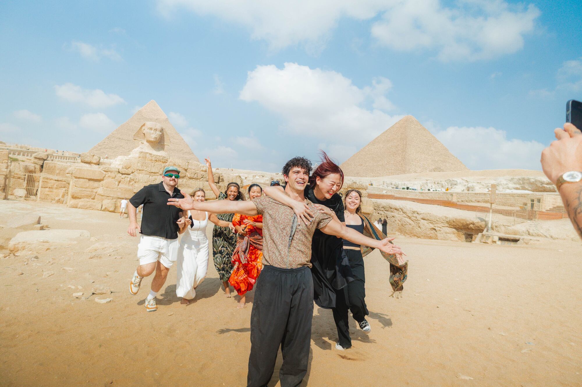 A group of people standing in front of a pyramid
