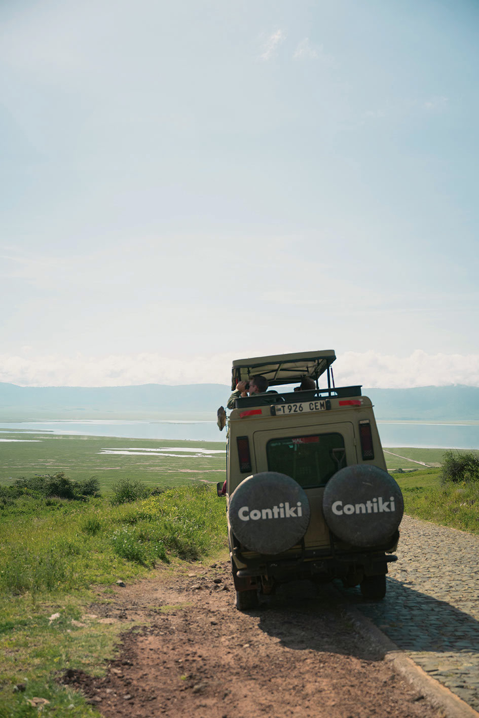 Safari truck driving down a dirt road in Serengeti, Tanzania