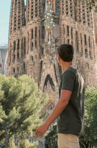 Barcelona's spectacular Sagrada Família towers above a traveller exploring the city on the Contiki Best of Spain Tour
