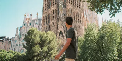 Barcelona's spectacular Sagrada Família towers above a traveller exploring the city on the Contiki Best of Spain Tour