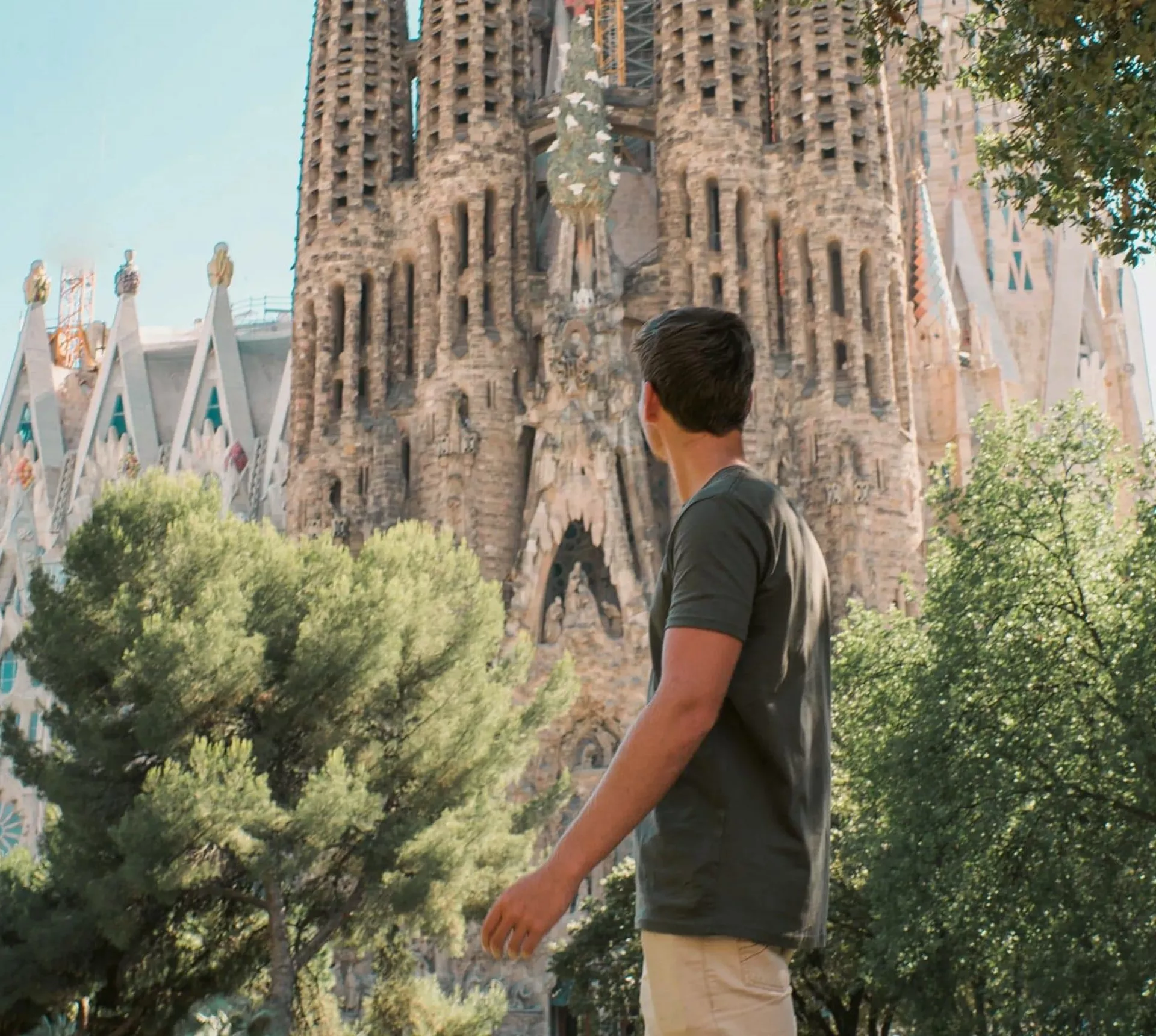 Barcelona's spectacular Sagrada Família towers above a traveller exploring the city on the Contiki Best of Spain Tour