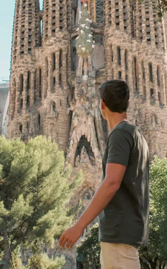 Barcelona's spectacular Sagrada Família towers above a traveller exploring the city on the Contiki Best of Spain Tour