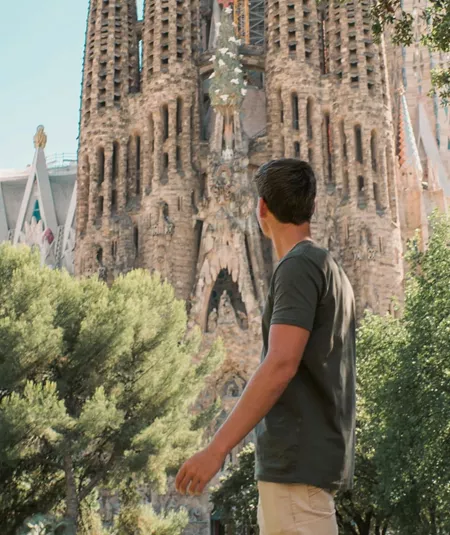 Barcelona's spectacular Sagrada Família towers above a traveller exploring the city on the Contiki Best of Spain Tour