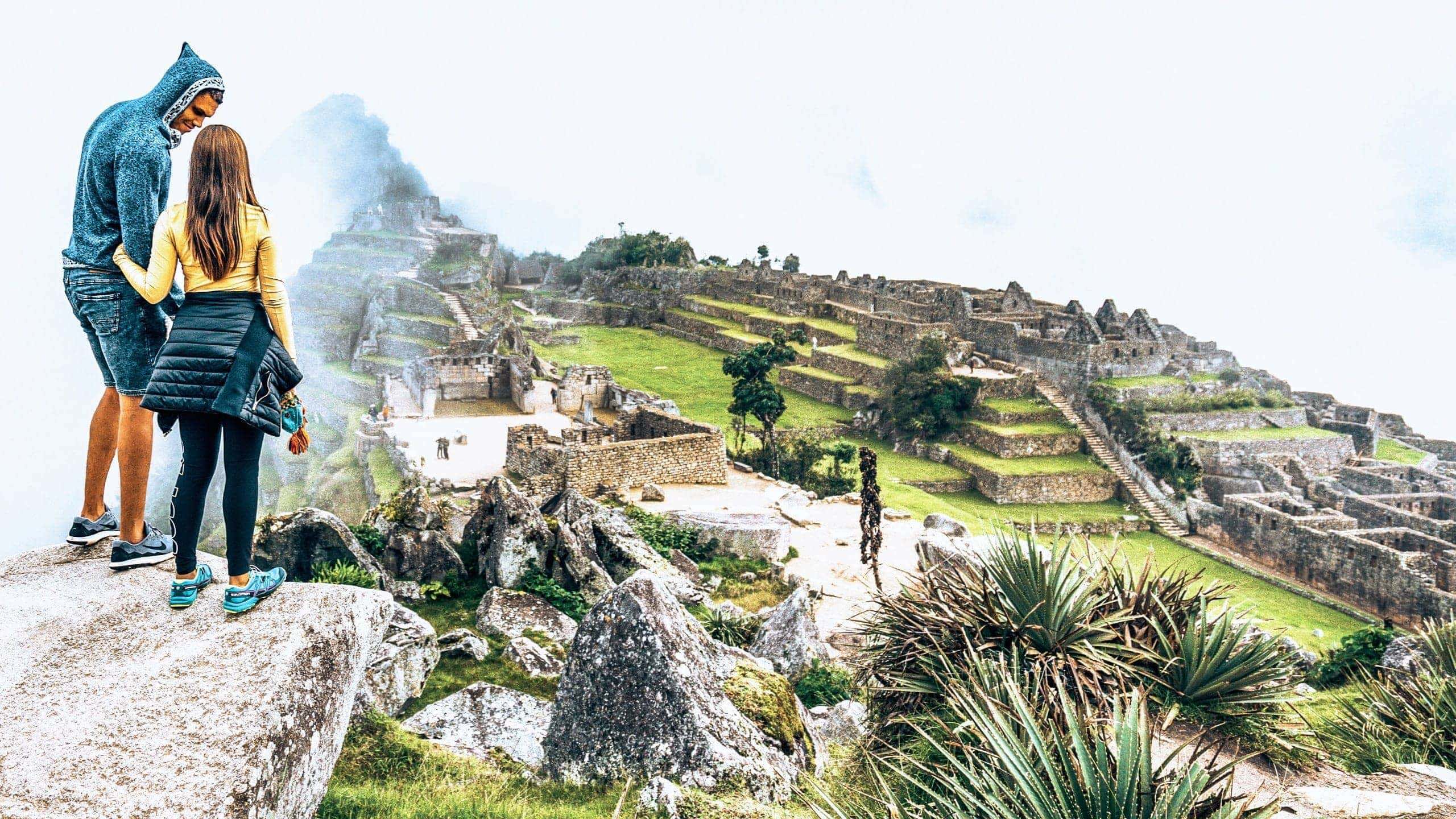 Machu Picchu emerges through the clouds as Contiki travellers admire Peru's iconic Inca citadel on Contiki's Lima to La Paz Tour