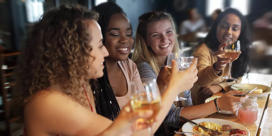Travellers enjoying a dinner together and toasting wine