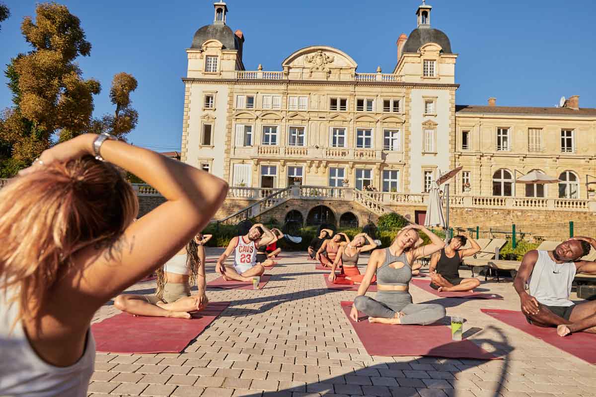 People Doing Yoga Outside Of Contiki Chateau In France
