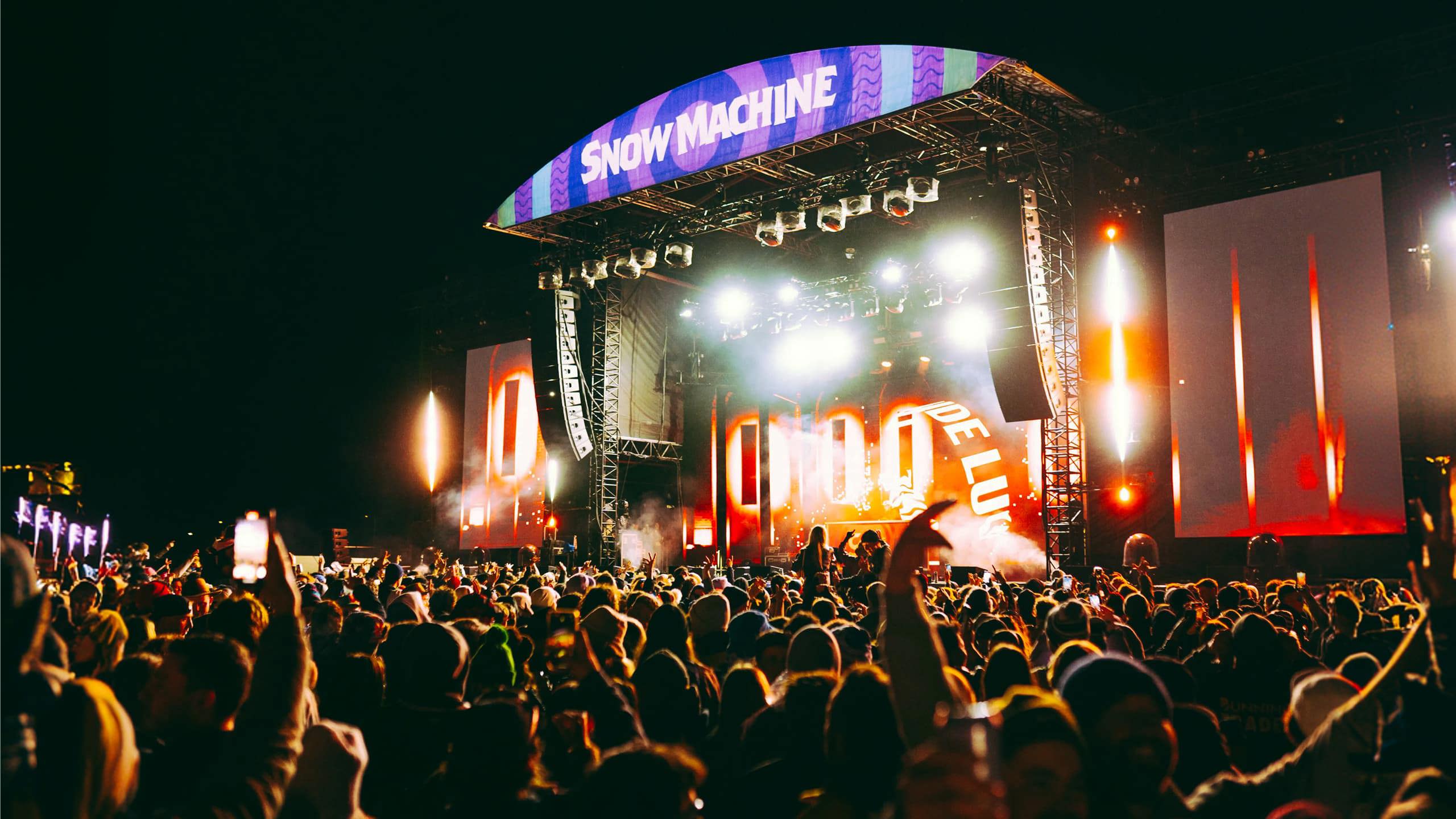 Large crowd at the Snow Machine music festival main stage with dramatic lighting in New Zealand at night - Contiki Snow Machine Festival NZ Tour