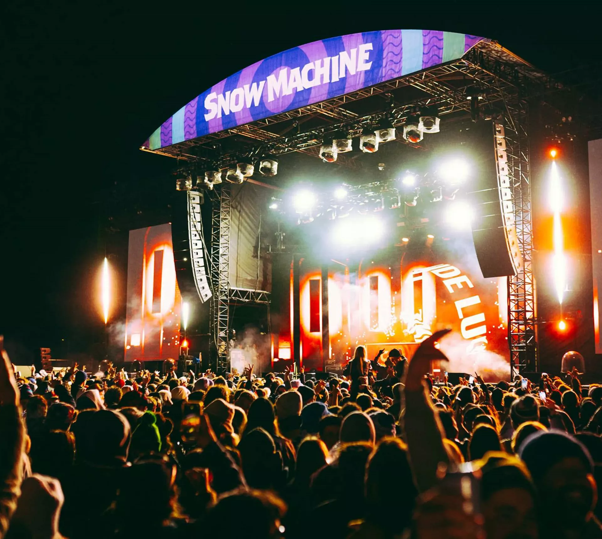 Large crowd at the Snow Machine music festival main stage with dramatic lighting in New Zealand at night - Contiki Snow Machine Festival NZ Tour