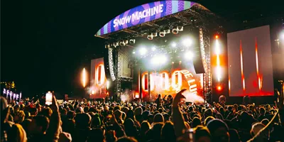 Large crowd at the Snow Machine music festival main stage with dramatic lighting in New Zealand at night - Contiki Snow Machine Festival NZ Tour