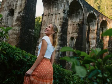 Female admiring the Nine Arch Bridge surrounded by lush forest in Ella, Sri Lanka - Contiki Best of Sri Lanka Tour