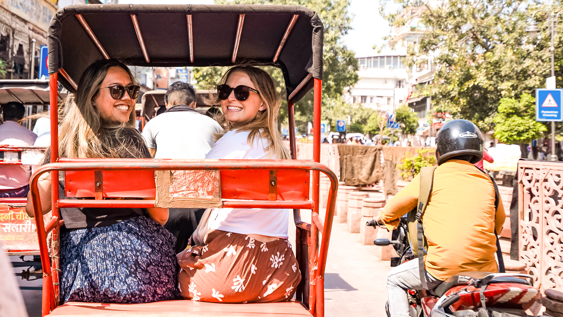 Two travellers smiling from the back of a Tuk Tuk, Phnom Penh, Cambodia