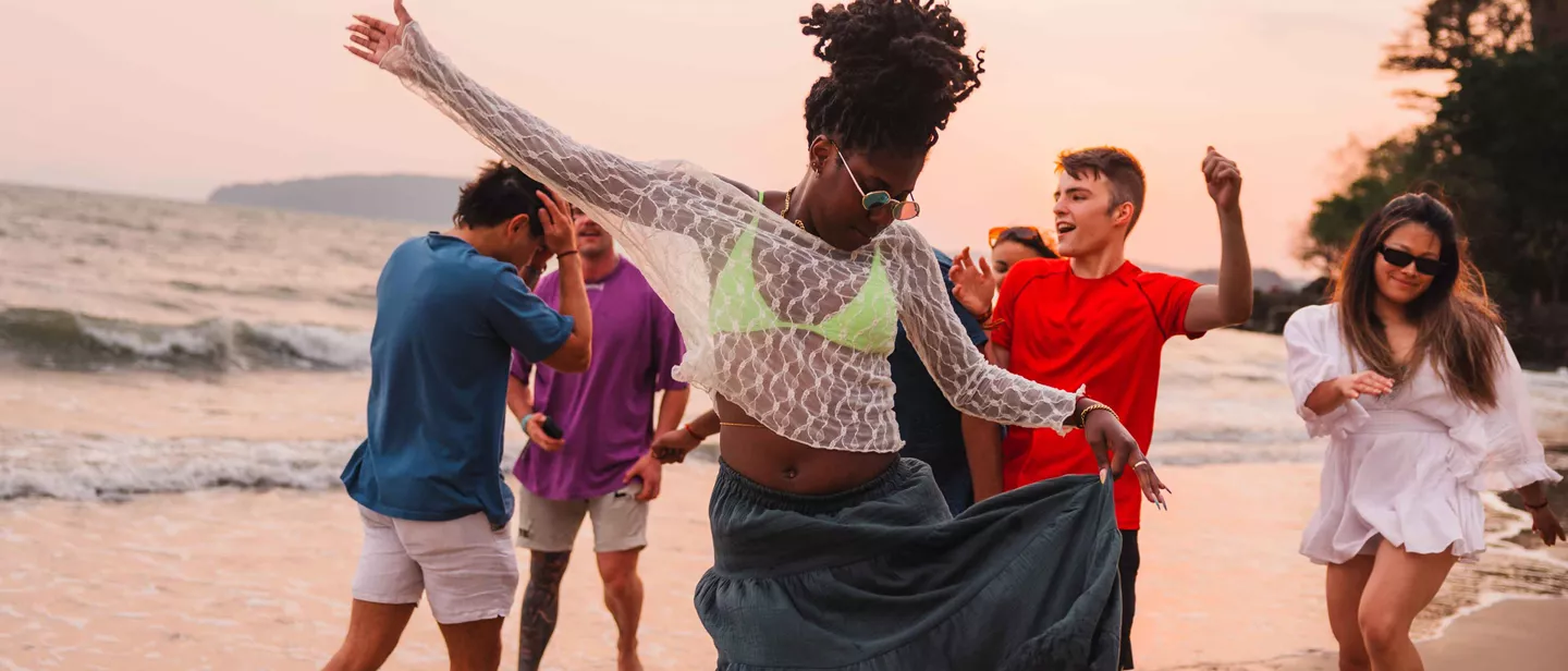 Travellers Dancing On The Beach In Thailand At Sunset