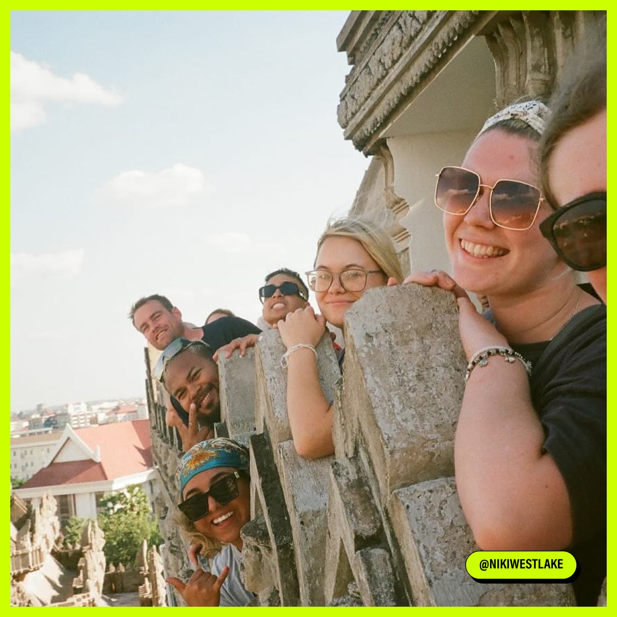 Group of people smiling and posing to the photo near the building