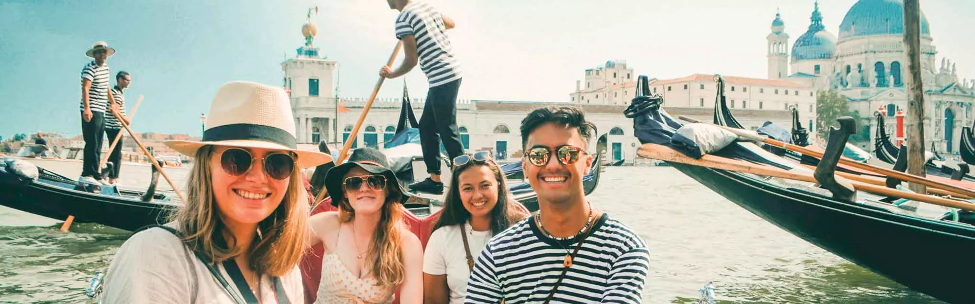 the world best tour Group Of Youg Travelers On Gondolo In Venice Italy