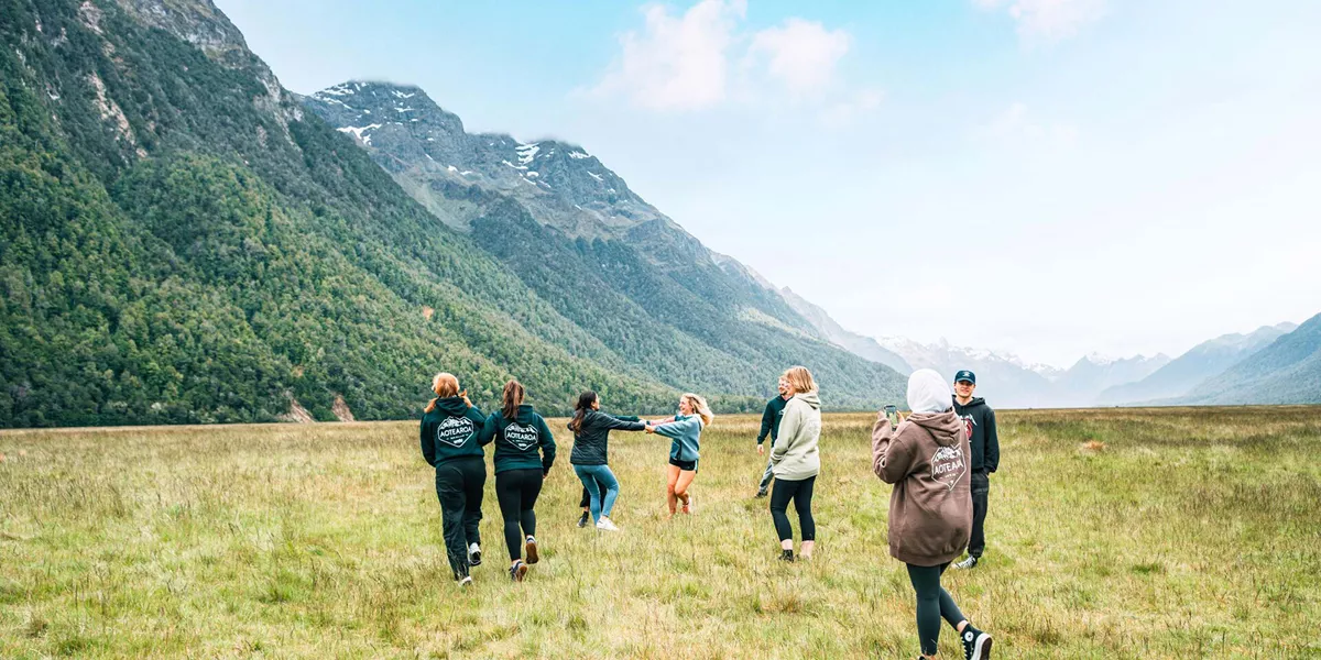 Group Of People Enjoying A Mountain Landscape Green Grass
