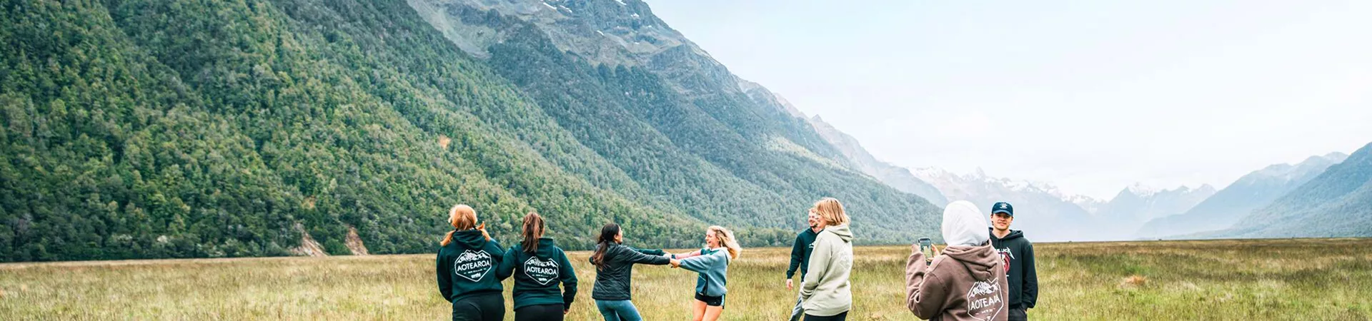 Group Of People Enjoying A Mountain Landscape Green Grass