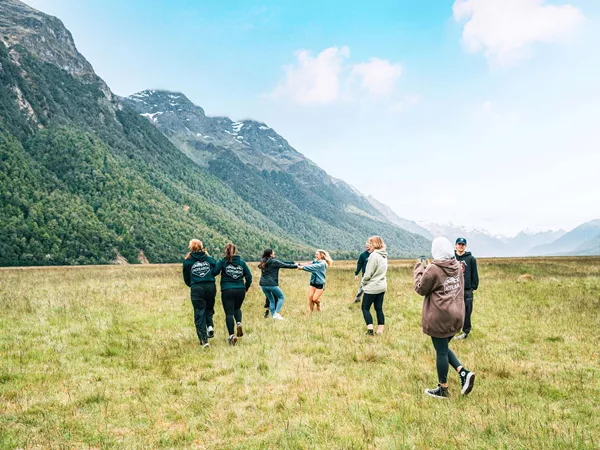 Group Of People Enjoying A Mountain Landscape Green Grass