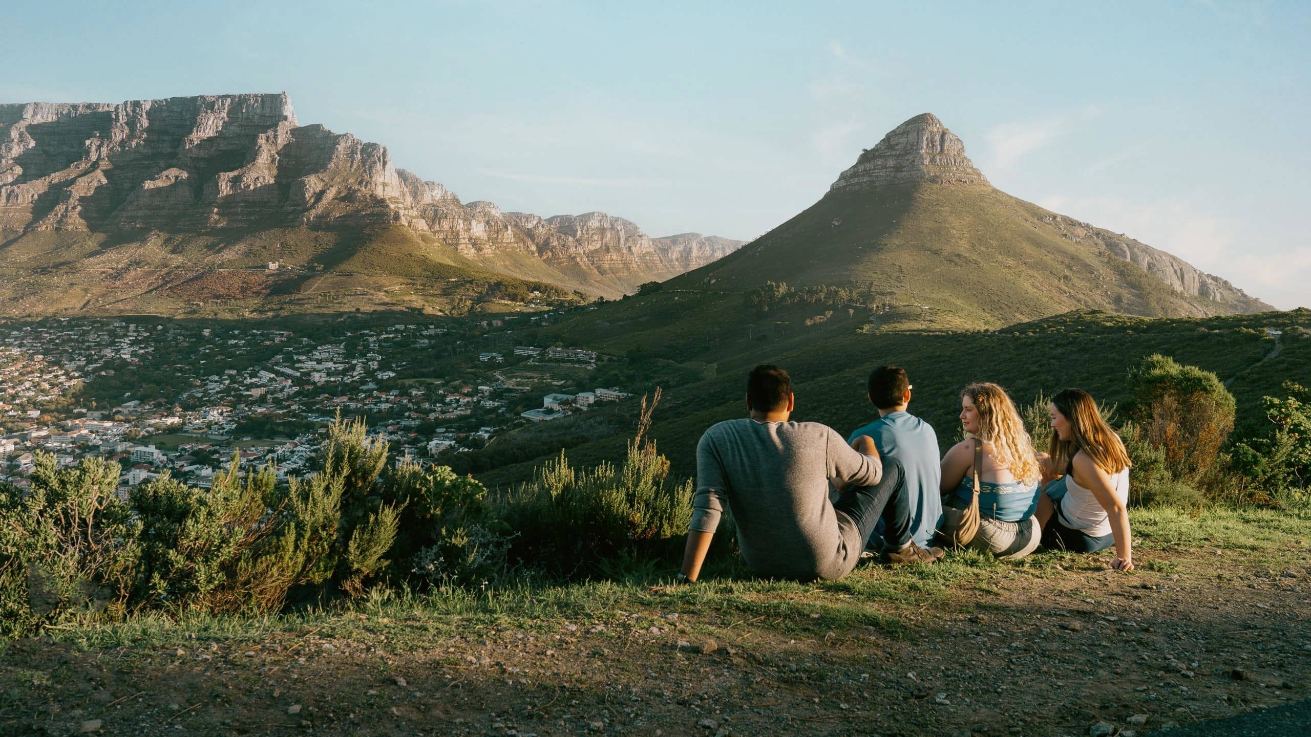 Travellers enjoy panoramic views of Table Mountain and Lion's Head overlooking Cape Town on the Contiki Cape Town, Safari & Falls Tour