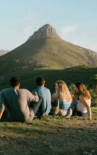 Travellers enjoy panoramic views of Table Mountain and Lion's Head overlooking Cape Town on the Contiki Cape Town, Safari & Falls Tour