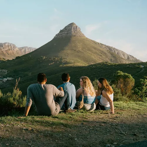 Travellers enjoy panoramic views of Table Mountain and Lion's Head overlooking Cape Town on the Contiki Cape Town, Safari & Falls Tour