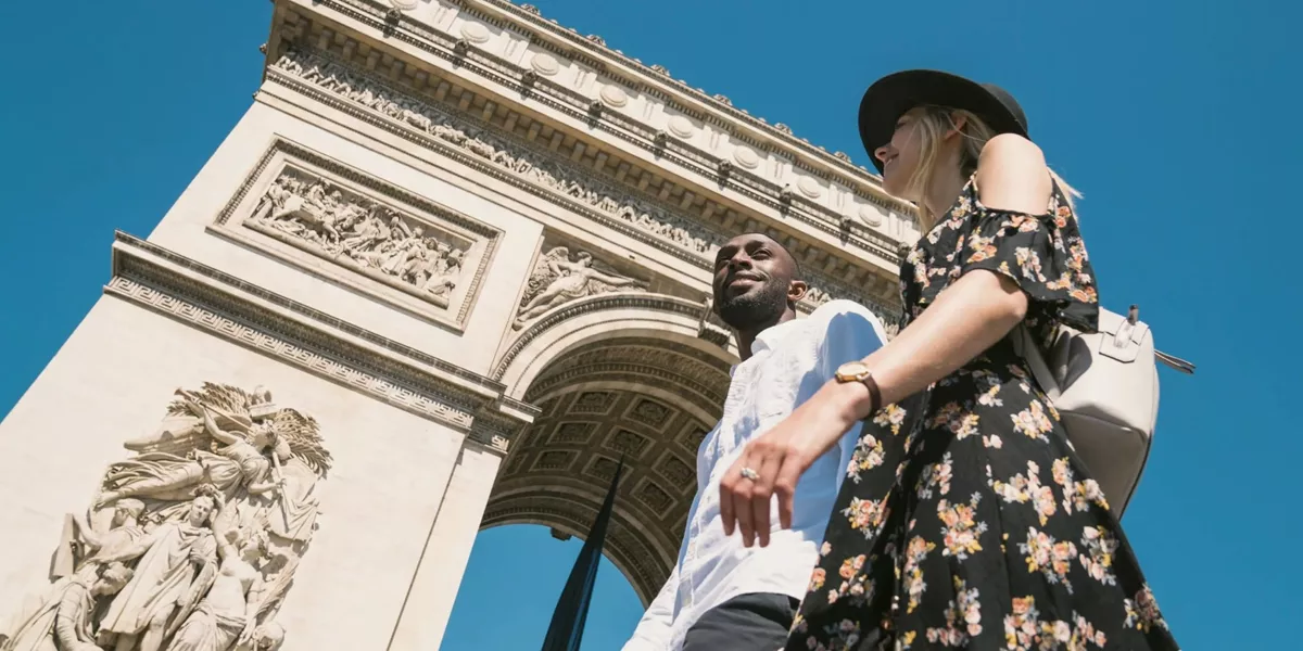 Contiki travellers visiting the Arc de Triomphe in Paris, France, during the London to Berlin by Train Tour, exploring iconic European landmarks and city sights