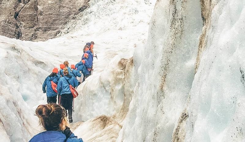 A group of tourists walking through glacier tunnels